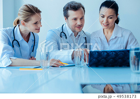 Competent doctor explaining situation to his assistants 49538173