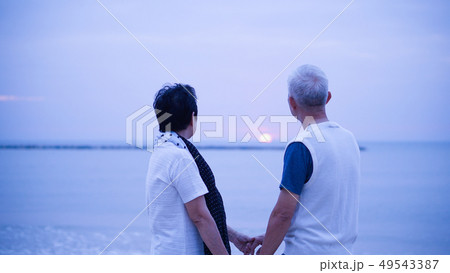 Asian senior couple dating at sunrise sea Asian senior couple dating at sunrise sea 49543387