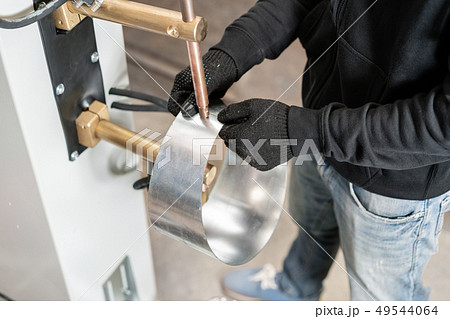 Operator is working with spot welding process. Two pieces of steel are melted together by electric 49544064