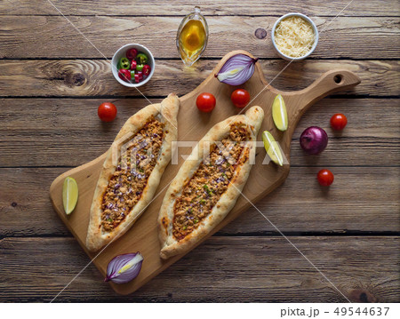 Two Turkish pizzas on a wooden table. Top view. 49544637