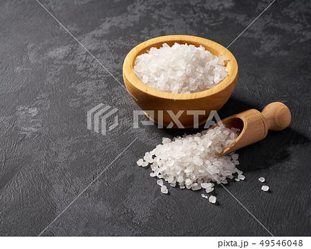 White salt  in wooden bowl on black background 49546048