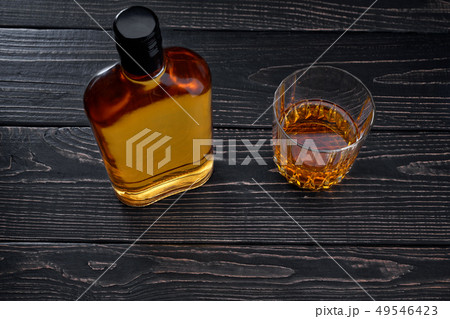 Bottle of whiskey on a black wooden table.Top Bottle of whiskey on a black wooden table.Top 49546423