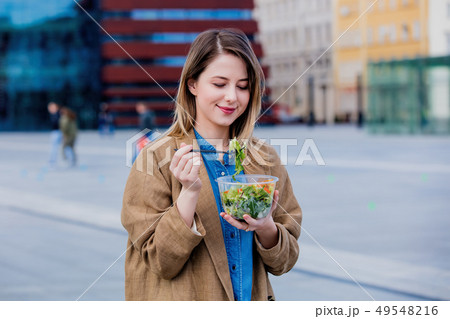 Young businesswoman with salad at urban city outdoor.  49548216