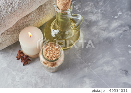 Towels, candle and massage oil on white table Towels, candle and massage oil on white table 49554031