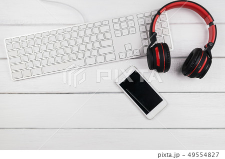 Headphone mobile phone and keyboard on wood 49554827
