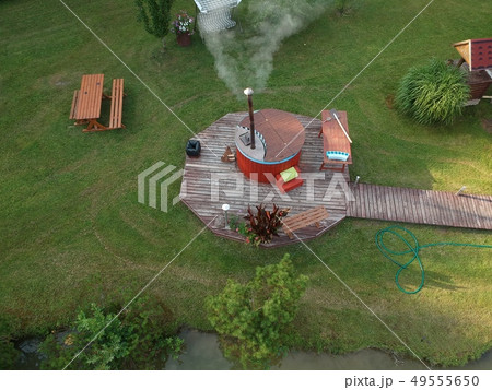 outdoor wooden barrel bath in summer garden, aerial 49555650