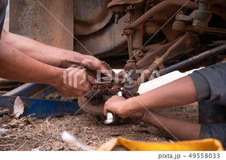 Hands of mechanic fixing wishbone control arm of Hands of mechanic fixing wishbone control arm of 49558033