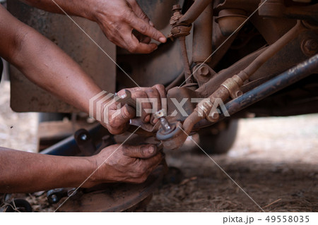 Hands of mechanic fixing wishbone control arm of Hands of mechanic fixing wishbone control arm of 49558035