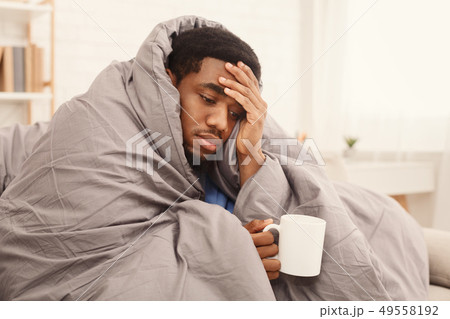 Sick african-american man drinking hot healing tea Sick african-american man drinking hot healing tea 49558192