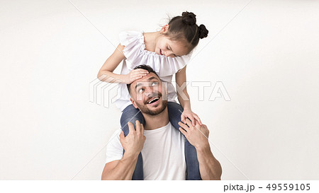 Cute little girl sitting on her dad shoulders and smiling to him 49559105