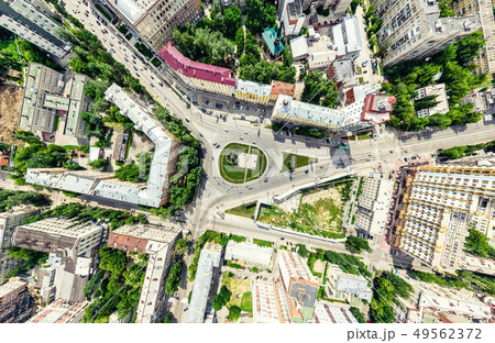 Aerial city view with crossroads and roads, houses, buildings, parks and parking lots. Sunny summer 49562372