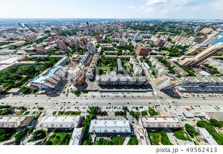 Aerial city view with crossroads and roads, houses, buildings, parks and parking lots. Sunny summer Aerial city view with crossroads and roads, houses, buildings, parks and parking lots. Sunny summer 49562413
