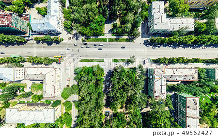 Aerial city view with crossroads and roads, houses, buildings, parks and parking lots. Sunny summer Aerial city view with crossroads and roads, houses, buildings, parks and parking lots. Sunny summer 49562427