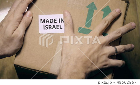 Placing sticker with MADE IN ISRAEL text on the box 49562867