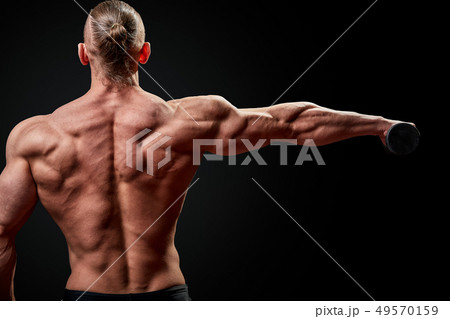 Athletic man posing. Photo of man with perfect physique on black background. Back view. Strength and 49570159
