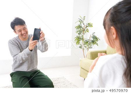 子どもたちの写真を撮るお父さん 49570970