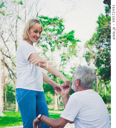 Happy old man kiss his wife hand at the park Happy old man kiss his wife hand at the park 49572491