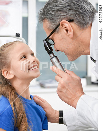 Oculist checking with special tool eyes of girl in clinic Oculist checking with special tool eyes of girl in clinic 49572608