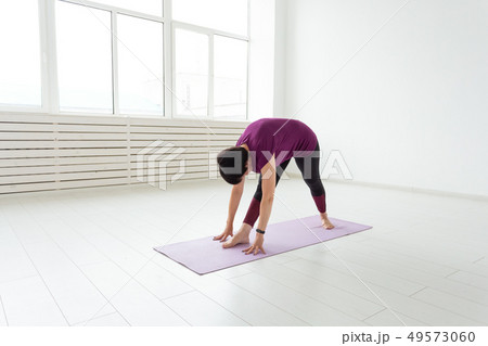 Healthy lifestyle, people and sport concept - Middle aged woman doing yoga 49573060