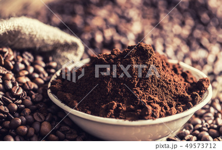Coffee powder in white bowl with beans. Coffee powder in white bowl with beans. 49573712