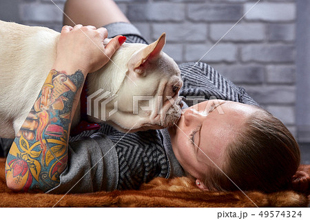 French bulldog on the hands of his master. It is felt that the girl loves her pet and hugs and kiss 49574324