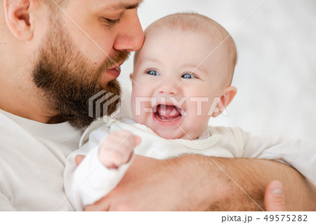Father tenderly touches his nose to child's cheek 49575282