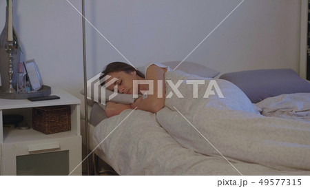Sleeping girl in her bedroom wakes up in the morning 49577315