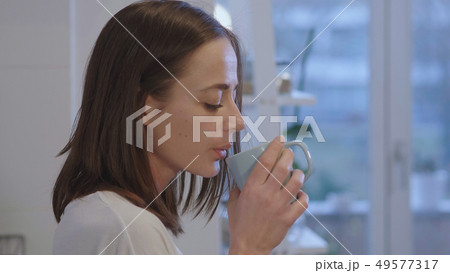 Tired girl in underwear drinks breakfast tea in the kitchen 49577317