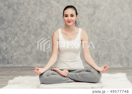 Young woman yoga on carpet at home living room. 49577748