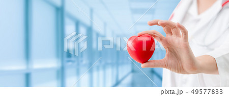 Doctor holding a red heart at hospital office. Doctor holding a red heart at hospital office. 49577833