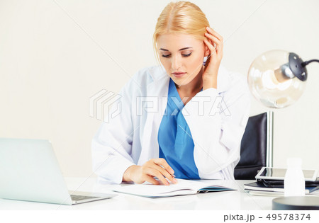 Doctor in hospital working on medical report. 49578374