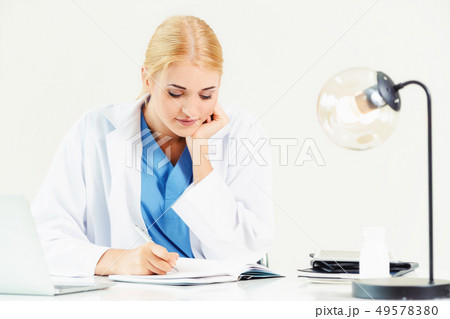 Doctor in hospital working on medical report. 49578380
