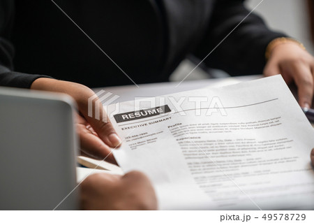 Candidate hands resume to the interviewer. 49578729