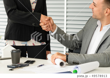 Businessman handshake businesswoman in office. Businessman handshake businesswoman in office. 49578913