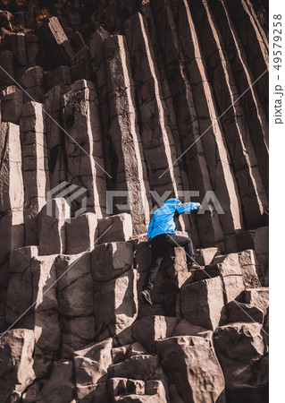 Traveler on hexagonal rocks in Vik, Iceland. 49579258