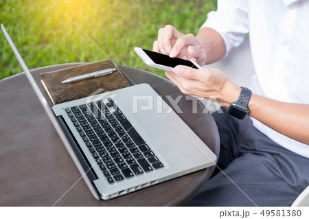 Man working on modern laptop sitting outside 49581380