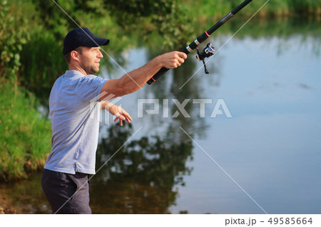 Man throws bait. Fisherman with fishing rod Man throws bait. Fisherman with fishing rod 49585664