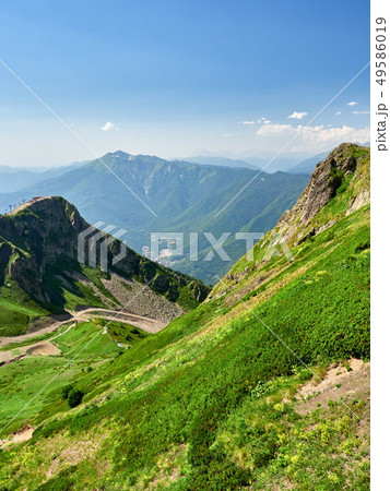 The peaks of a high mountain slope with cable car The peaks of a high mountain slope with cable car 49586019