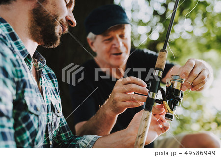Old Father with Bearded Son Fishing on River. Old Father with Bearded Son Fishing on River. 49586949
