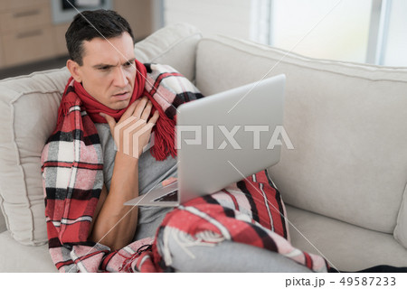 Man with Cold Sitting on Sofa in Checkered Blanket 49587233