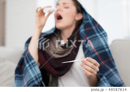 Upset Woman with Cold on Sofa in Scarf at Home. Upset Woman with Cold on Sofa in Scarf at Home. 49587614