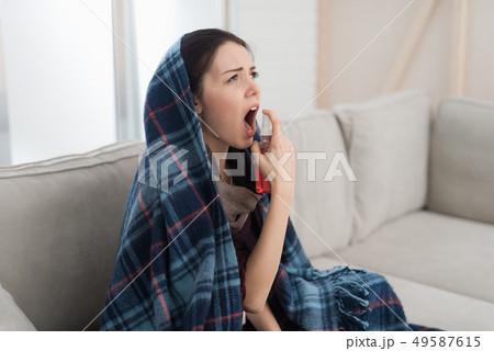 Upset Woman with Cold on Sofa in Scarf at Home. Upset Woman with Cold on Sofa in Scarf at Home. 49587615
