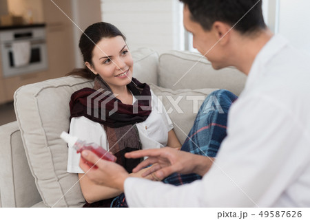 Doctor Visiting Sick Young Woman in Scarf at Home. 49587626