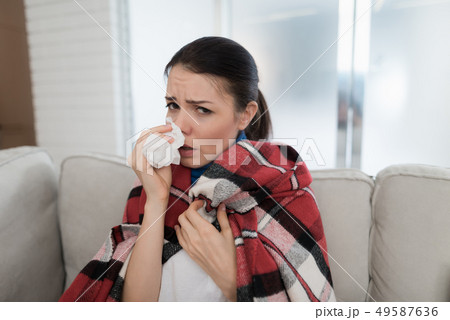 Woman with Cold on Sofa in Checkered Blanket. Woman with Cold on Sofa in Checkered Blanket. 49587636