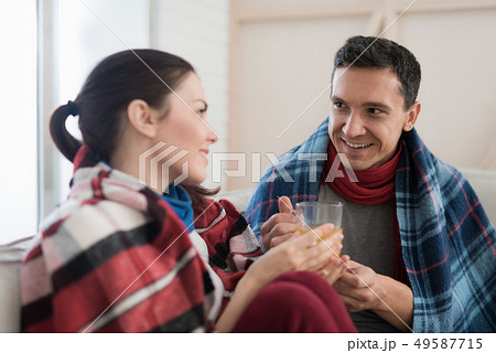 Sick Couple Sitting on Sofa in Checkered Blankets. Sick Couple Sitting on Sofa in Checkered Blankets. 49587715