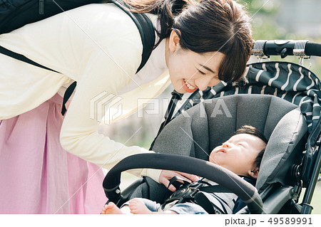 ベビーカーの赤ちゃんをあやす母親　散歩　子育て　育児 49589991
