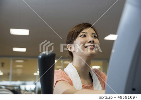 スポーツジムイメージ　エアロバイクに乗る女性 49591097