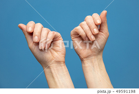 young woman showing hands on blue background. Attractive presentation of hands and nails 49591198