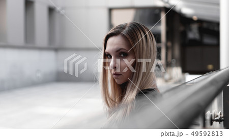 Urban style blonde girl with a stern look. Girl power and subculture concept. Urban style blonde girl with a stern look. Girl power and subculture concept. 49592813