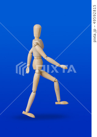 Walking wooden toy figure on blue Walking wooden toy figure on blue 49592815